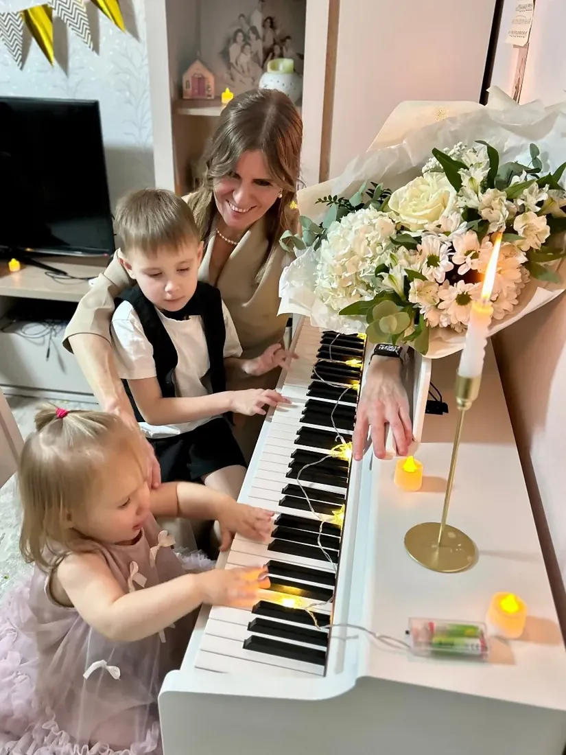 Взрослый показывает детям, как играть, за цифровым пианино Grace CP-200